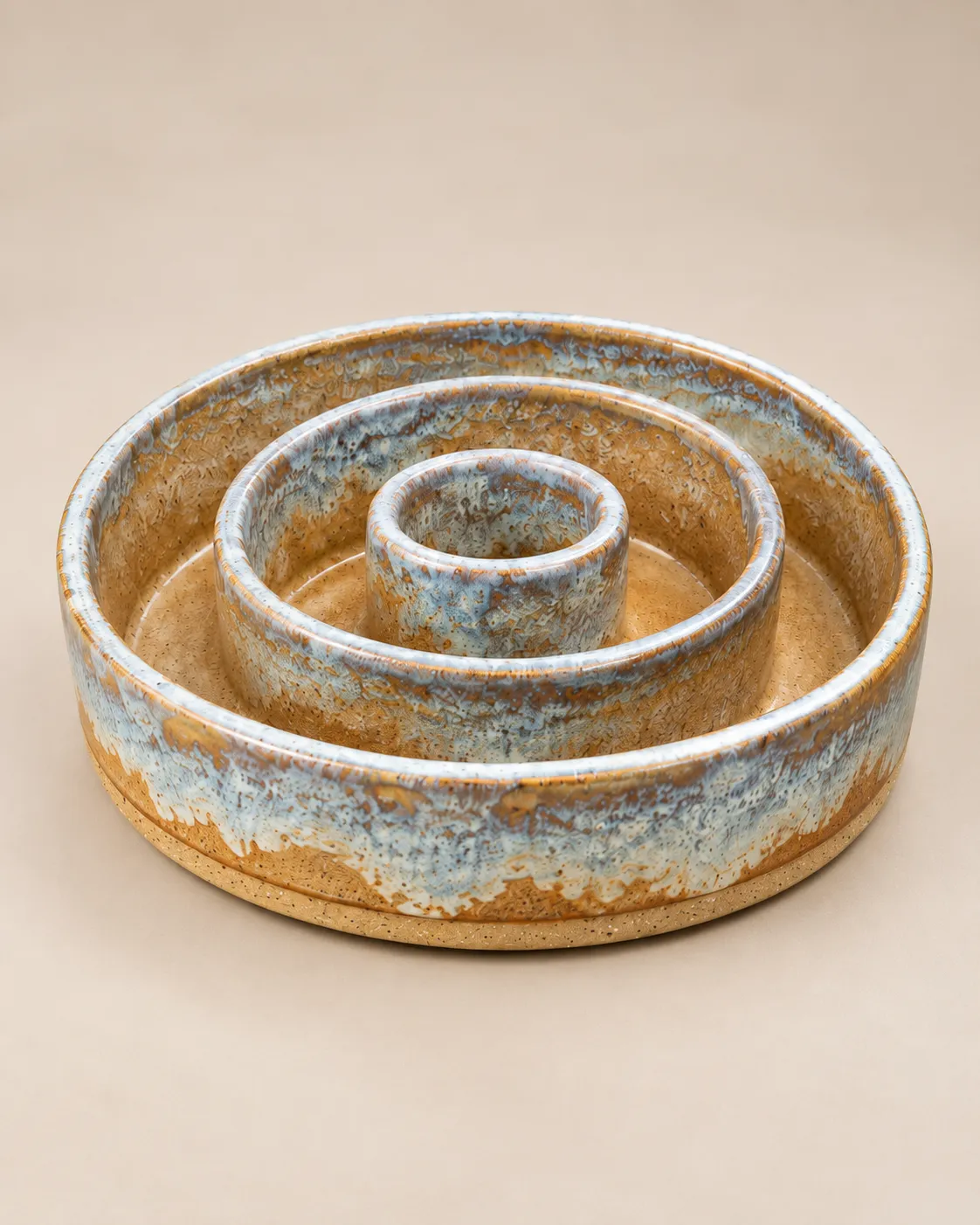 Ringed slow-feeder dog bowl in variegated blue-white and amber glaze