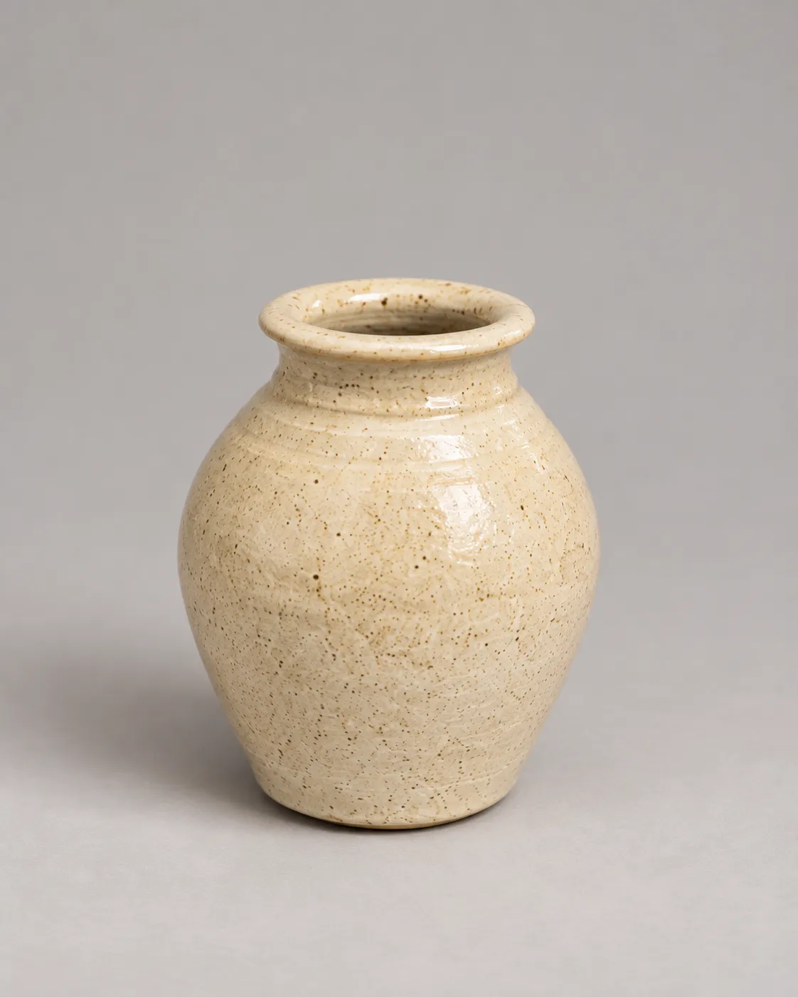 Speckled cream vase with rolled rim and smooth body