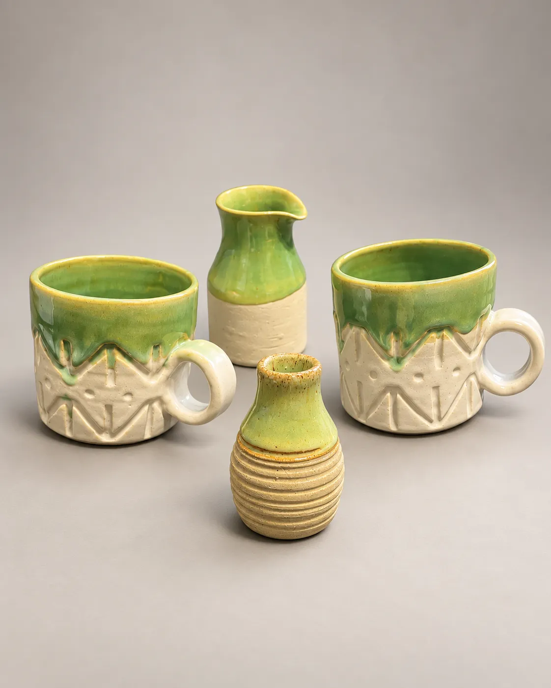 Pistachio glaze set: two carved mugs, a pour vase, and a ribbed bud vase