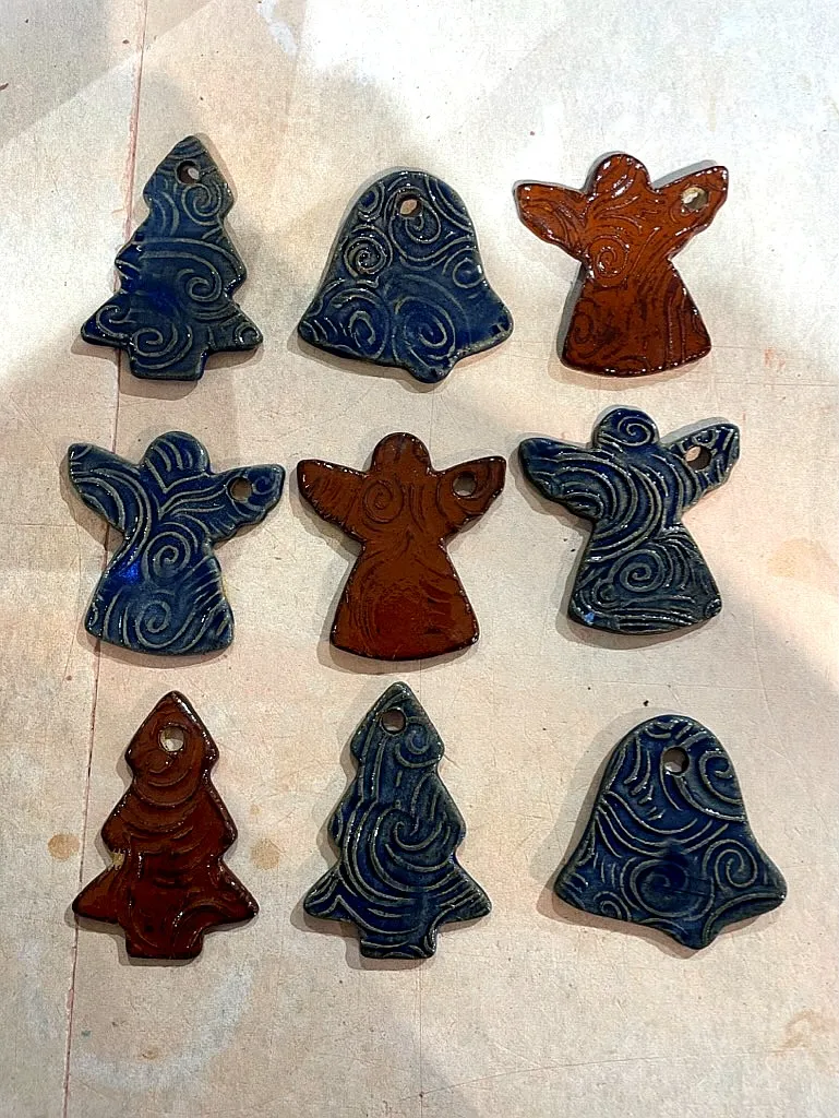Blue and terracotta glazed ornaments in tree, bell, and angel shapes