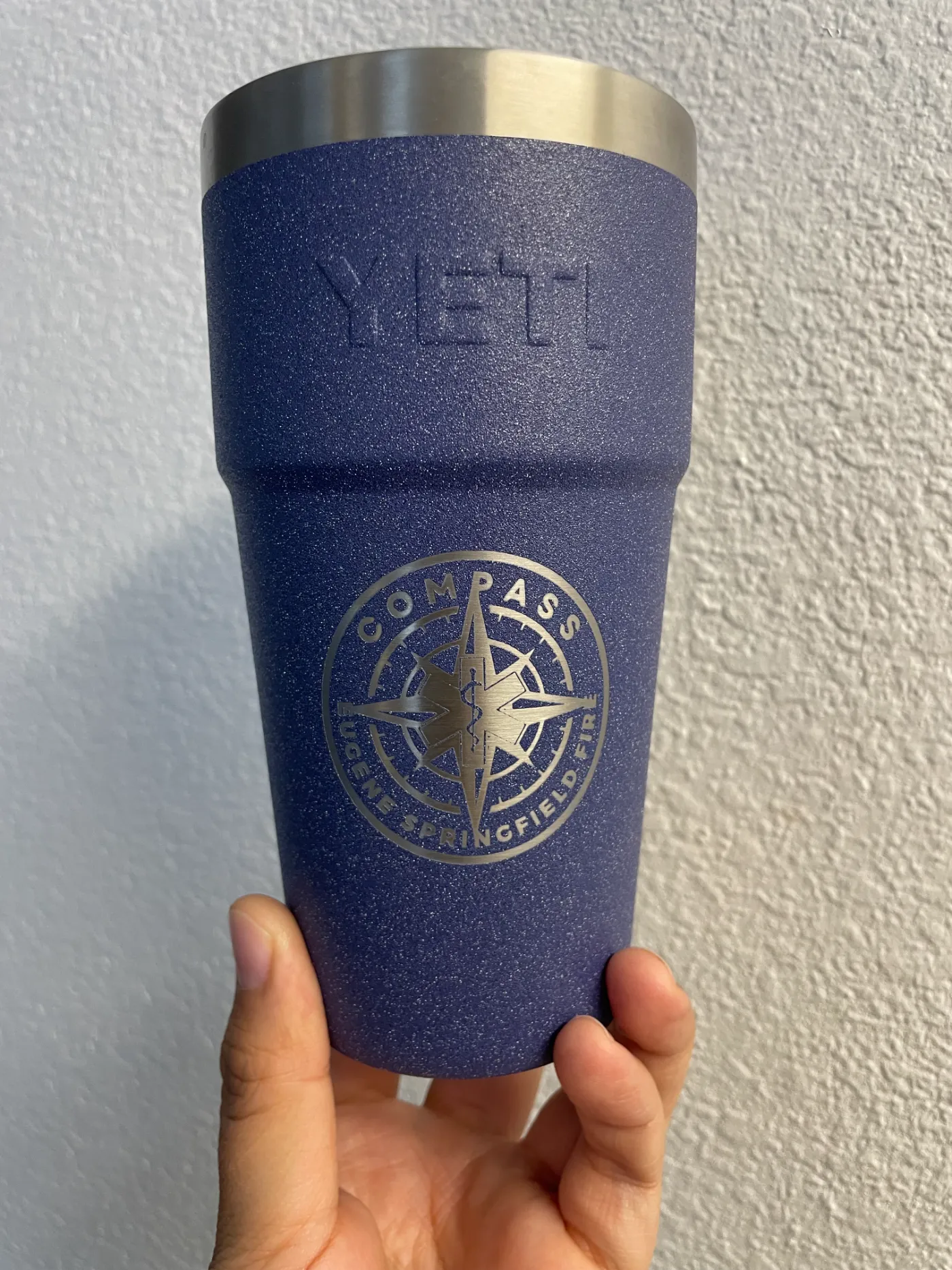COMPASS logo engraved on a navy tumbler
